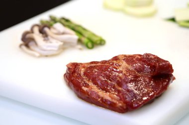 Çiğ et, mantar ve kuşkonmaz pişirmeye hazır.