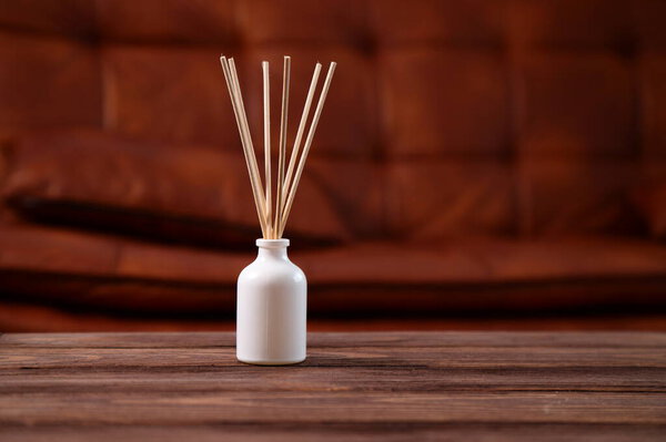 Aroma diffuser on wooden table, aromatic sticks for home