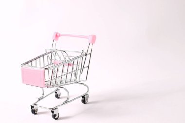 Beyaz arka planda mini alışveriş arabası
