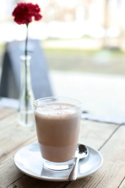 Kafedeki ahşap masada bir fincan kahve.