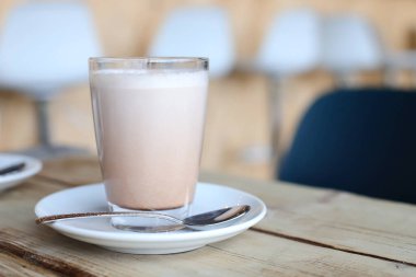 Kafedeki ahşap masada bir fincan kahve.