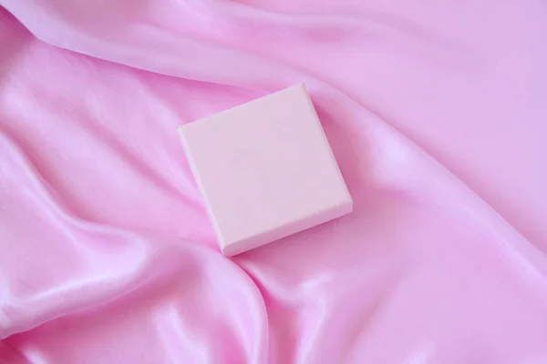Pink present box mockup on silk background, copy space