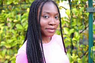 Siyah, afro saçlı, sokaklarda saç stili olan genç bir kız.