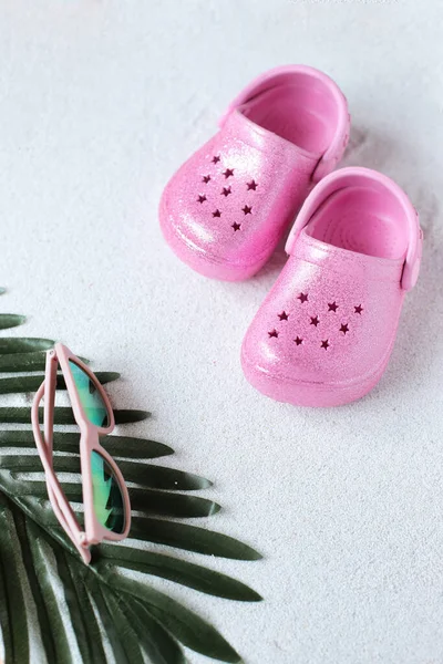 stock image Pink child shoes and sunglasses on the beach, kid vacation vibe