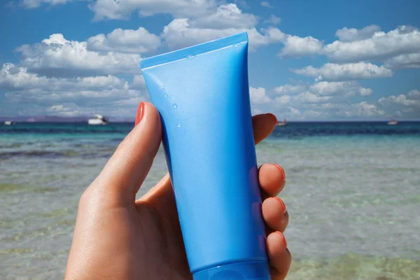 Spf krem tüpü kadın eli üzerinde, yaz plaj koruması boş.