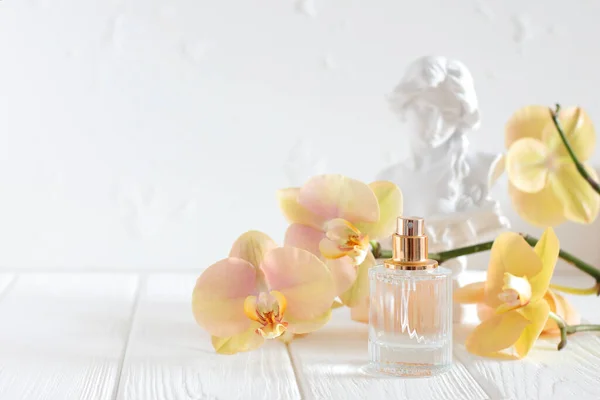 玻璃香水瓶喷兰花和雕塑 — 图库照片