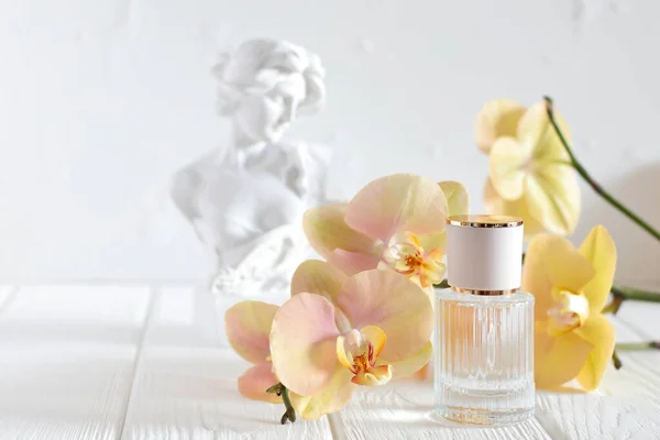 glass perfume bottle spray with orchid flowers and sculpture