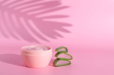 Taze aloe vera dilimleri ile kozmetik krem şişesi, mesaj için yer