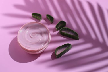 Taze aloe vera dilimleri ile kozmetik krem şişesi, mesaj için yer