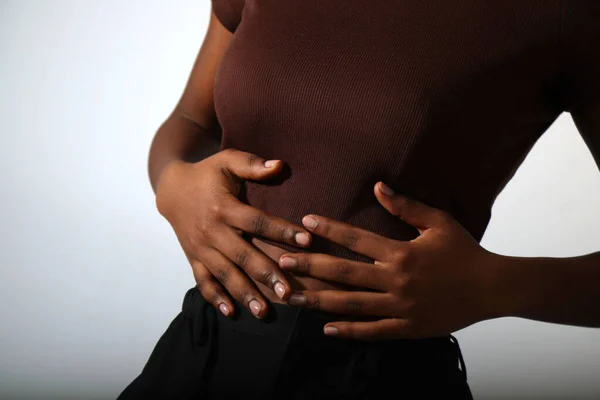 Çıplak manikür tırnakları ve vücut parçaları olan Afro kadın elleri.