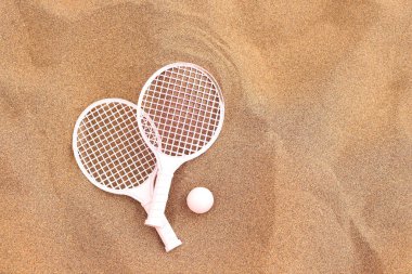Plaj tenis raketleri ve top kumsalda, yaz tatili aktiviteleri