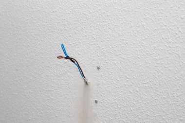 Görülen kablolarla evdeki elektrik prizi tamiri. Yeni elektrik prizleri patlak. Elektrik kabloları, elektrik kabloları, eski bir beton bina duvarındaki soket, ev yenileme.