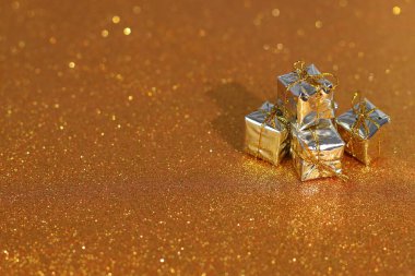Noel için altın renkli hediye kutusu, parlak arka planda yeni yıl hediyesi.