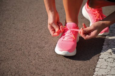 Koşu ayakkabıları için pembe spor ayakkabı bağlayan kız koşucu, yaşam tarzı imajı