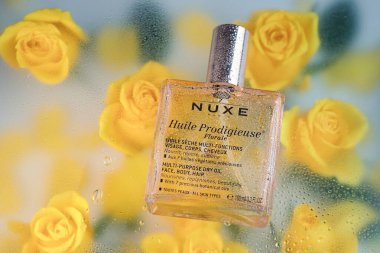 NUXE (124; HUILE PRODIGIEUSE FLORALE FLORALE NOURISHING Yağ Şişe sarı gül arka planlı, Vitoria-Gasteiz, Ekim 2023