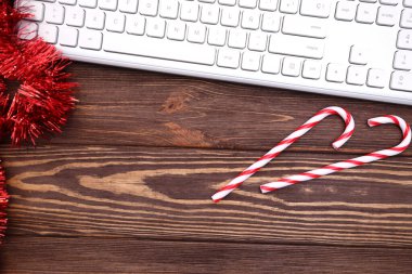 Kahverengi ahşap masaüstünde dizüstü bilgisayar klavyesi ve Noel ve yeni yıl dekorasyonu