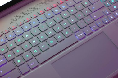 Renkli arka ışıklandırmalı neon bir bilgisayar klavyesi üzerinde çalışıyorum. Bilgisayar oyunları, hackleme, teknoloji, internet konsepti. Seçili odak.