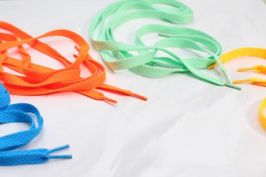 Farklı parlak renkler beyaz arkaplanda birçok ayakkabı bağcığı