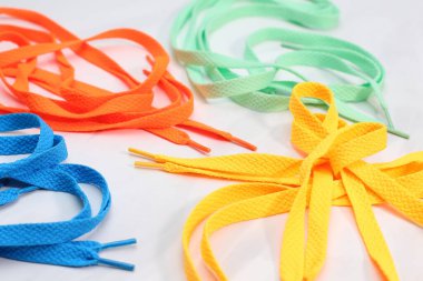 Farklı parlak renkler beyaz arkaplanda birçok ayakkabı bağcığı