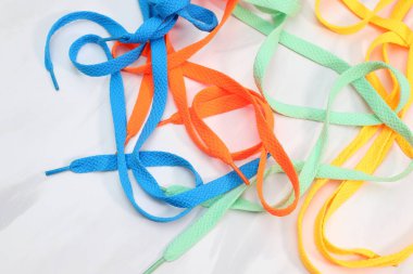 Farklı parlak renkler beyaz arkaplanda birçok ayakkabı bağcığı