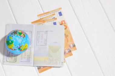Seyahat konsepti, pasaport, dünya ve para beyaz arka planda, kopyalama alanı