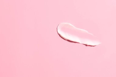 Pembe arka planda beyaz krem ezilmesi, kozmetik doku lekesi