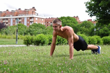 Genç erkek, dışarıda esneme sporu, sağlıklı yaşam konsepti yapıyor.