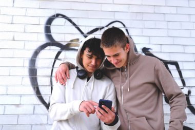 Latin Amerikalı bir genç, zeki telefonuyla Causacian çocuğuna, teknoloji kavramına ve gençlere