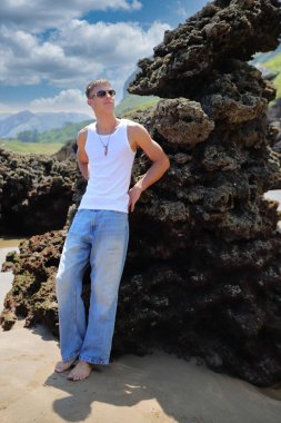 Plajda güneş gözlüklü genç, sıradan bir genç, yaz yaşam tarzı.