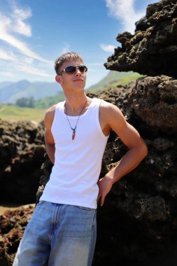 Plajda güneş gözlüklü genç, sıradan bir genç, yaz yaşam tarzı.