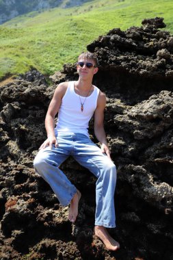 Plajda güneş gözlüklü genç, sıradan bir genç, yaz yaşam tarzı.