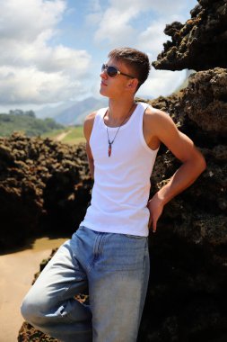 Plajda güneş gözlüklü genç, sıradan bir genç, yaz yaşam tarzı.