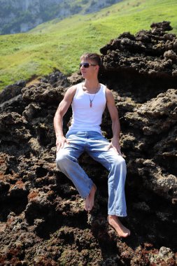 Plajda güneş gözlüklü genç, sıradan bir genç, yaz yaşam tarzı.