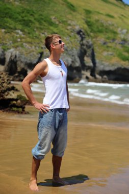 Plajda güneş gözlüklü genç, sıradan bir genç, yaz yaşam tarzı.