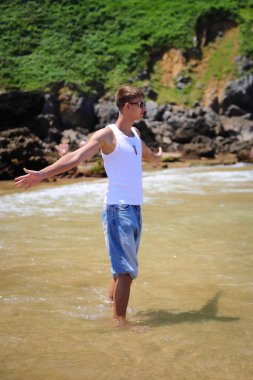 Plajda güneş gözlüklü genç, sıradan bir genç, yaz yaşam tarzı.