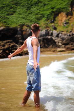 Plajda güneş gözlüklü genç, sıradan bir genç, yaz yaşam tarzı.