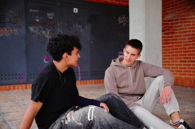 Dışarıda oturan ve gülen iki genç öğrenci, birliktelik kavramı.