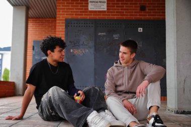 Dışarıda oturan ve gülen iki genç öğrenci, birliktelik kavramı.