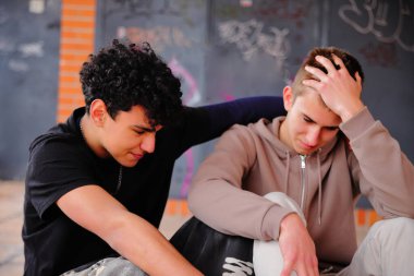 Dışarıda oturan ve gülen iki genç öğrenci, birliktelik kavramı.