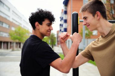 Parkta spor yapan iki genç adam, genç arkadaşlar, aktif spor yaşam tarzı, arkadaşlık konsepti.