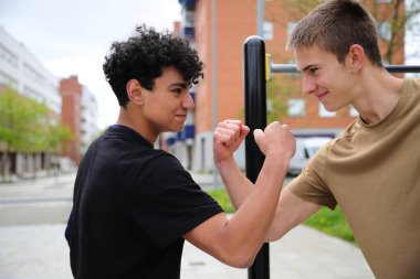 Parkta spor yapan iki genç adam, genç arkadaşlar, aktif spor yaşam tarzı, arkadaşlık konsepti.