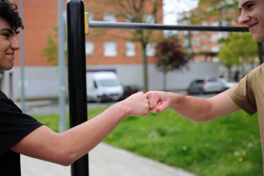 Parkta spor yapan iki genç adam, genç arkadaşlar, aktif spor yaşam tarzı, arkadaşlık konsepti.