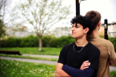 Parkta spor yapan iki genç adam, genç arkadaşlar, aktif spor yaşam tarzı, arkadaşlık konsepti.