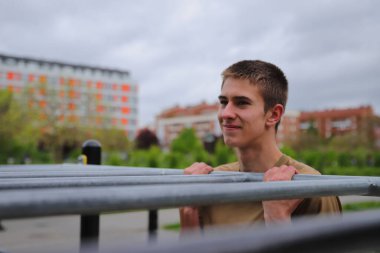 Genç erkek spor barlarında egzersiz yapıyor, sağlıklı yaşam tarzı, açık hava fitness konsepti