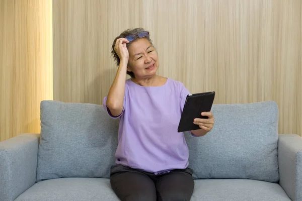 Asian Retired Elderly Eyeglasses Sitting Sofa Watching Tablet Computer Presbyopia — Stock Photo, Image