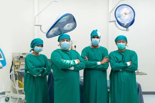 手術室で手術を行う前に 外科医と看護師のグループは 手術室で動作を実行する前に 彼らの腕を自信を持って立って緑色のガウン — ストック写真