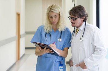 Kafkasyalı kıdemli doktor bir hastane koridorunda hemşireyle tartışıyor. Hastanedeki hastalar üzerinde çalışan bir grup doktor. Tıbbi personel raporları analiz ediyor ve klinikte çalışıyor..