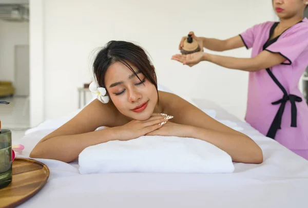 若いアジアの女性はスパマッサージを取得します マッサージテーブルの上に寝そべって 目を閉じてリラックス スパタイの治療美容ボディのためのアロマセラピー スパ美容マッサージ 健康ウェルネス — ストック写真