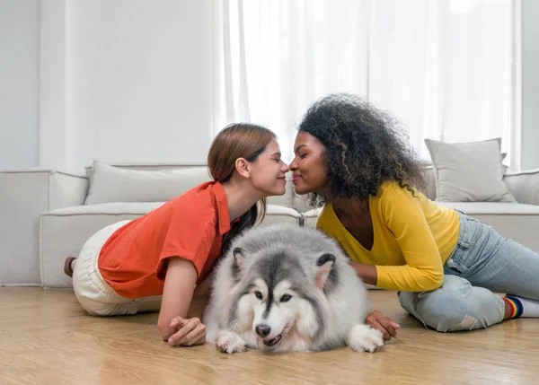 2人の若い多様なレズビアン女性が自宅のリビングルームでペットと時間を過ごしています 多様性 Lgbt ジェンダーアイデンティティの概念 — ストック写真