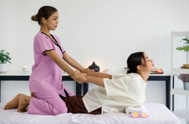 Rahatlama felsefesi Tayland 'da sakin bir spa' da vücut bulmuştur. Yetenekli bir terapist sıcak ışıkla sarmalanmış bir kadına nazikçe masaj yapar. Sakinleştirici Asya dekorlarının arasında..